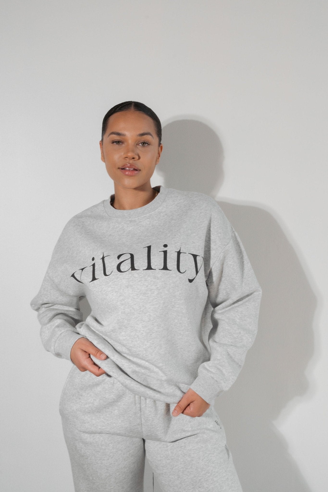 A woman wearing the Vitality Cozy Uni Crew in Stone Marl