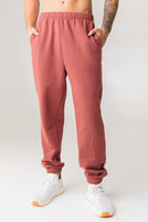 A man wearing the Vitality Uni Cozy Jogger in Rosewood