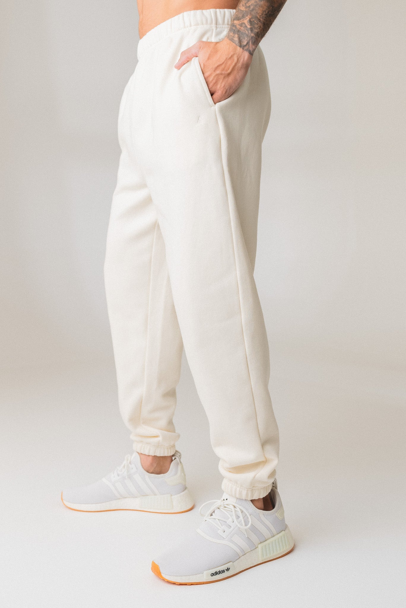A man wearing the Vitality Uni Cozy Jogger in Oat