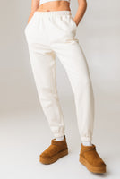 A woman wearing the Vitality Uni Cozy Jogger in Oat