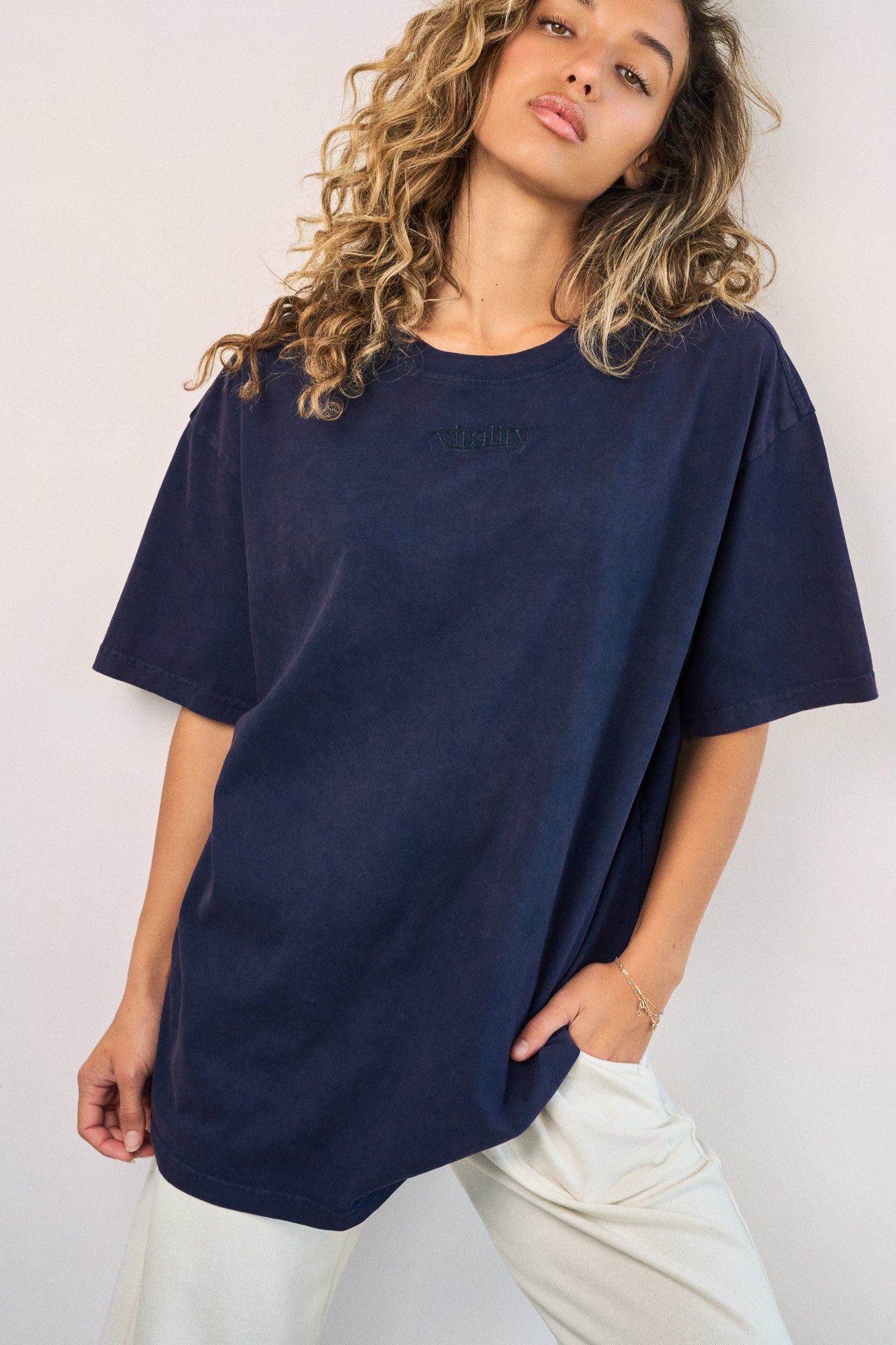 A woman wearing the Vitality Retro Uni Tee - Oxford Washed