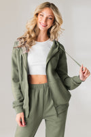 A woman wearing the Vitality Uni Cozy Zip in Willow