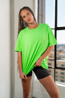 A woman wearing the Vitality Retro Uni Tee - Neon Green