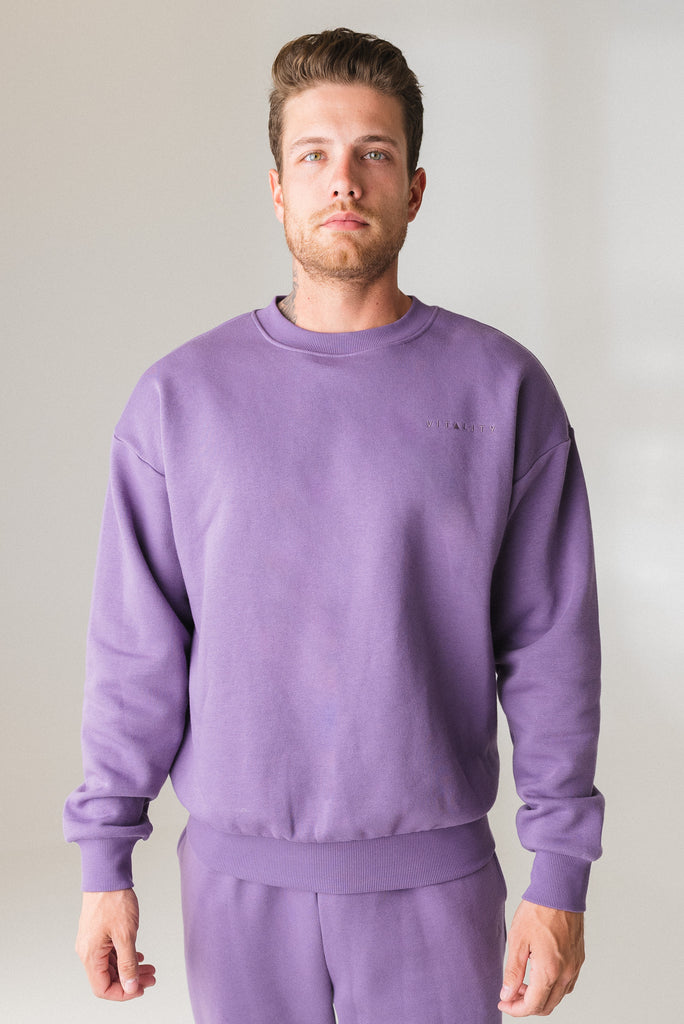 A man wearing the Vitality Uni Cozy Crew in Violet