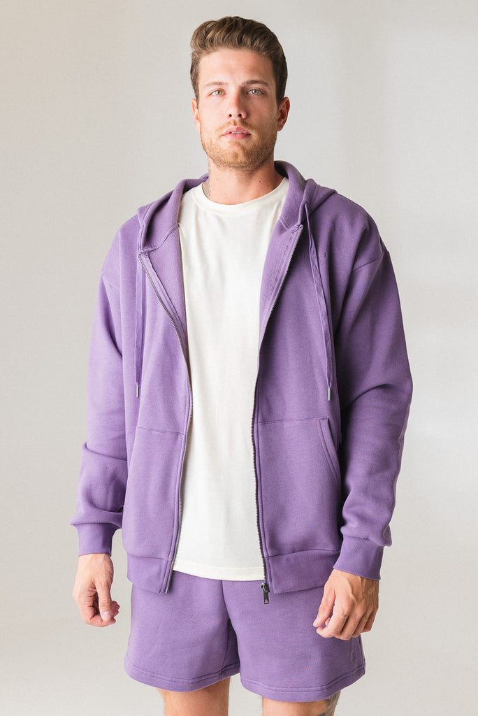 A man wearing the Vitality Uni Cozy Zip in Violet