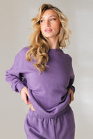A woman wearing the Vitality Uni Cozy Crew in Violet