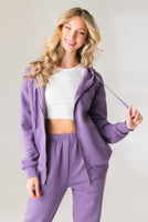 A woman wearing the Vitality Uni Cozy Zip in Violet