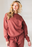 A woman wearing the Vitality Uni Cozy Crew in Rosewood