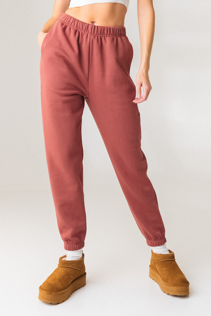 A woman wearing the Vitality Uni Cozy Jogger in Rosewood