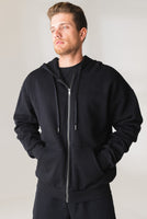 A man wearing the Vitality Uni Cozy Zip in Midnight