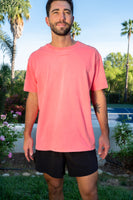 A man wearing the Vitality Retro Uni Tee - Neon Coral