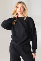 A woman wearing the Vitality Uni Cozy Crew in Midnight