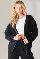 A woman wearing the Vitality Uni Cozy Zip in Midnight