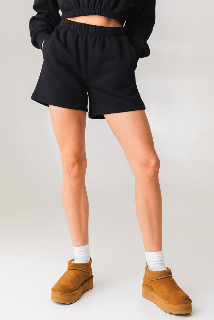 A woman wearing the Vitality Uni Cozy Short in Midnight