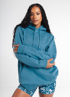 A woman wearing Vitality's Maker Hood in Teal