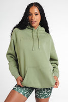 A woman wearing Vitality's Uni Maker Hood in Matcha