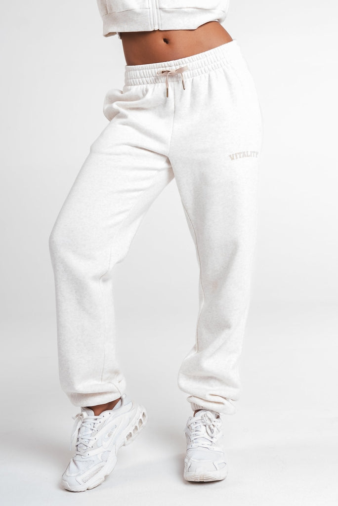 A woman wearing the Vitality Uni Cozy Jogger in Oat Marl